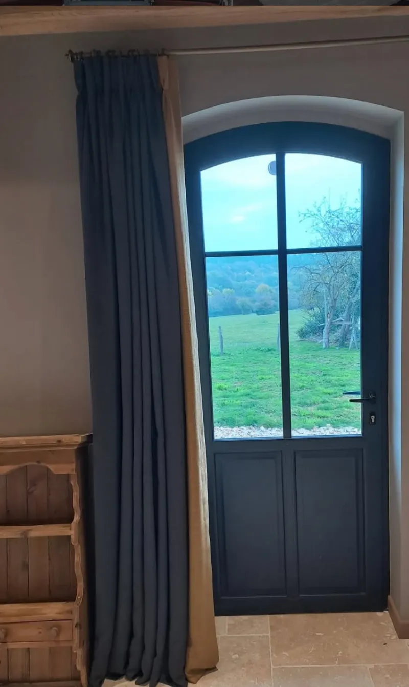 Rideaux sur mesure gris anthracite encadrant une porte-fenêtre